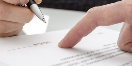 Woman signing a paper